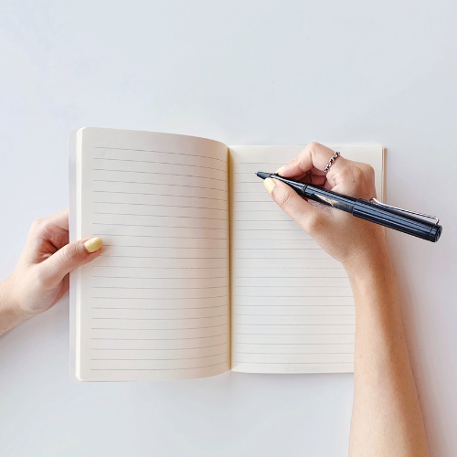 ręka z długopisem nad zeszytem